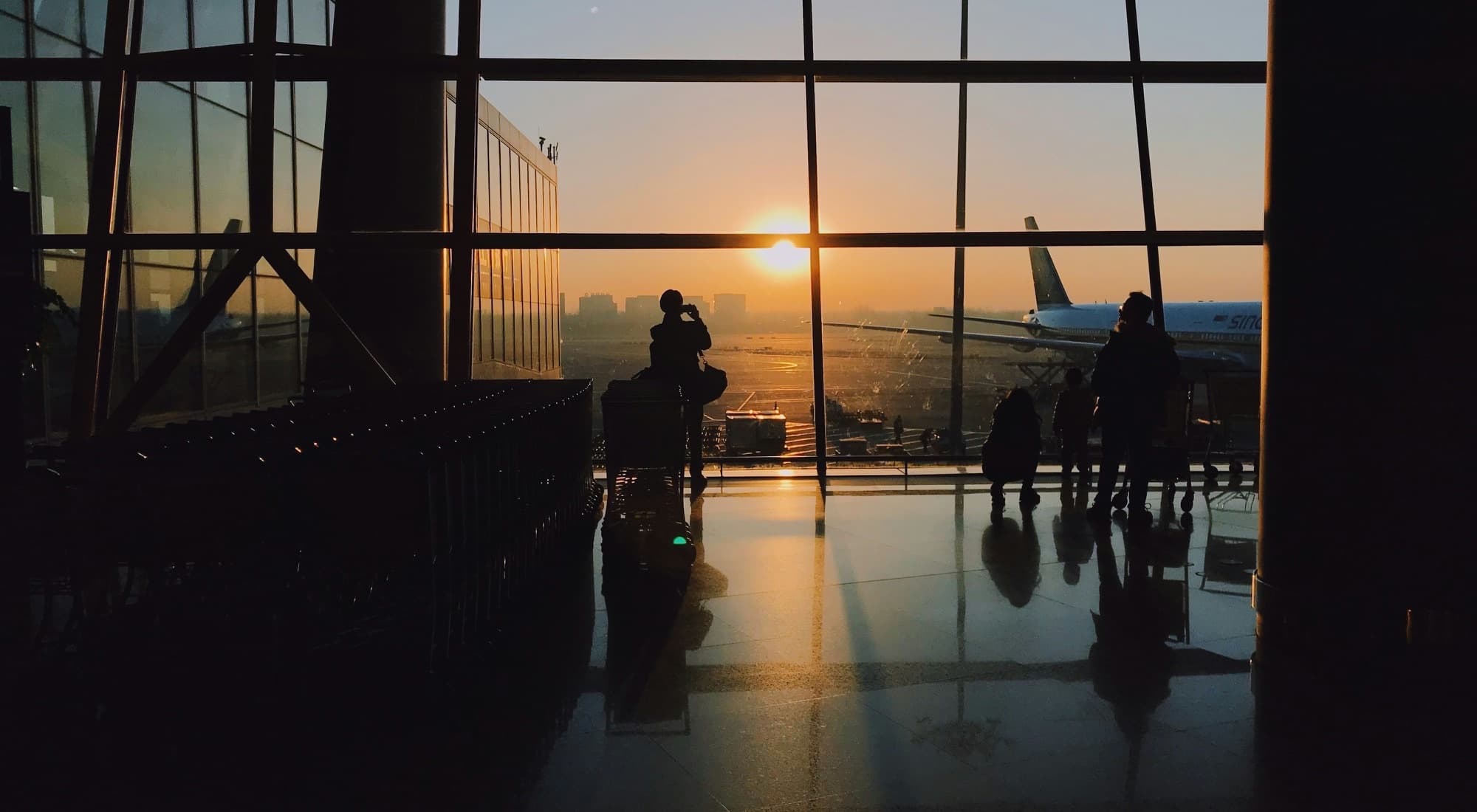 An airport departure lounge at sunset